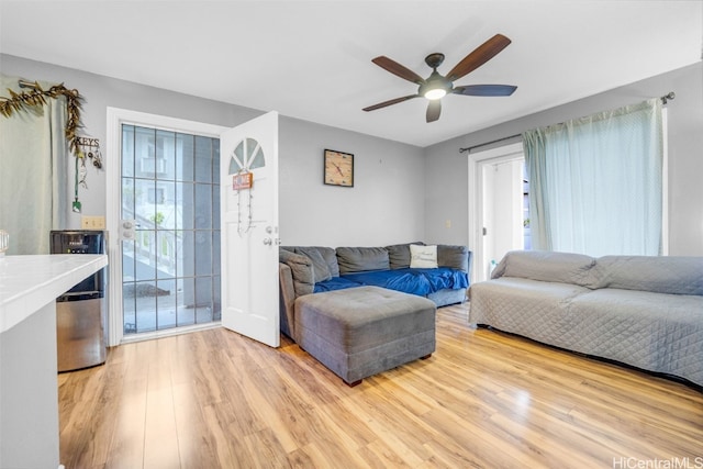 living room with light wood-type flooring and ceiling fan