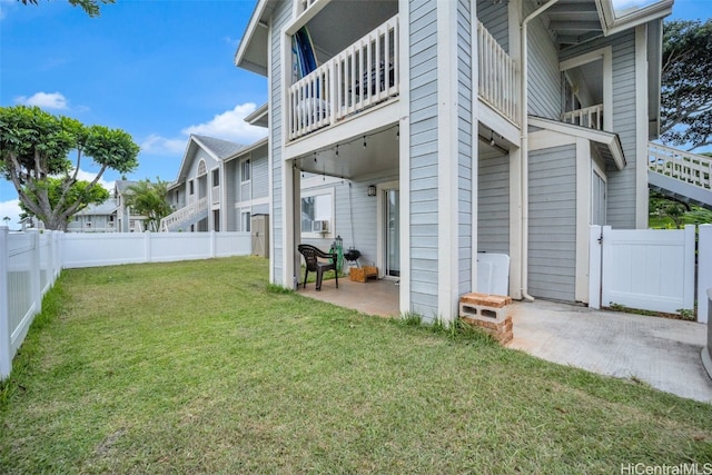 view of side of home featuring a yard, a balcony, and a patio area