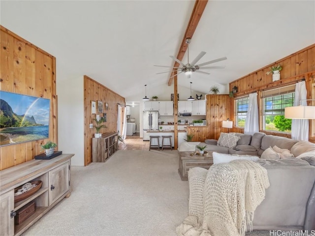 carpeted living room with vaulted ceiling with beams, wooden walls, and ceiling fan