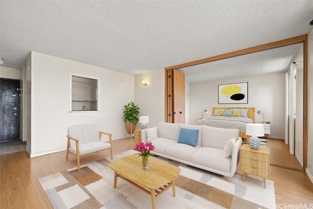 living room featuring light wood-type flooring and a textured ceiling