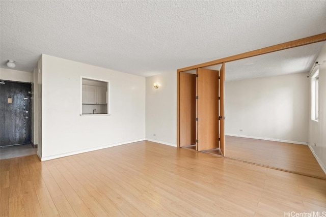 empty room featuring light hardwood / wood-style flooring and a textured ceiling