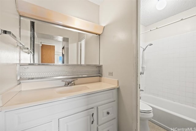 full bathroom featuring vanity, a textured ceiling, toilet, and tiled shower / bath