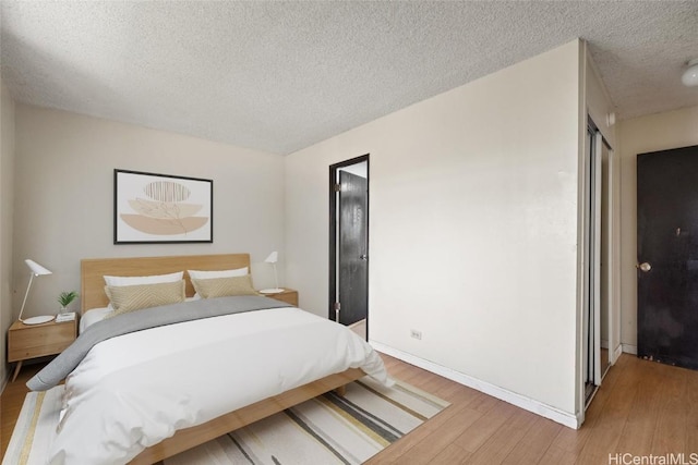 bedroom featuring a textured ceiling and hardwood / wood-style flooring