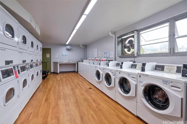 laundry room featuring independent washer and dryer, light hardwood / wood-style flooring, and stacked washer and clothes dryer