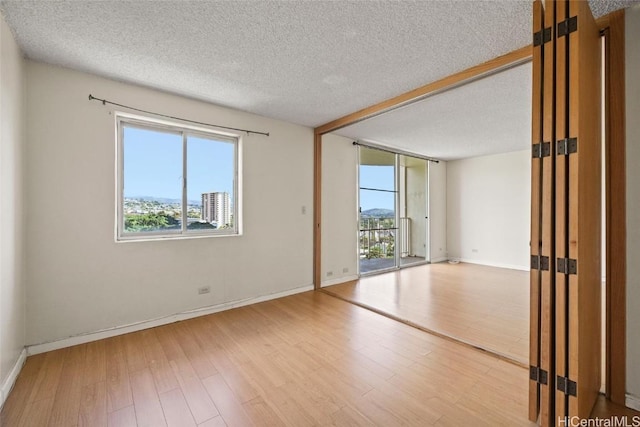 spare room with hardwood / wood-style floors and a textured ceiling