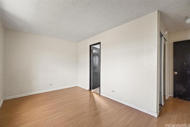 unfurnished room featuring a textured ceiling and light hardwood / wood-style flooring