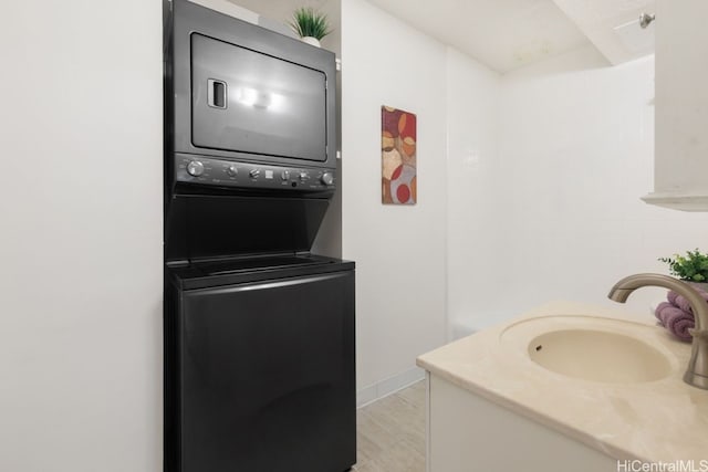 washroom featuring sink and stacked washing maching and dryer