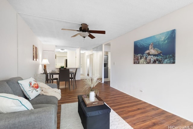 living room with ceiling fan, hardwood / wood-style floors, and a textured ceiling