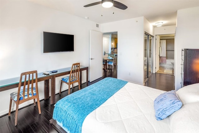 bedroom with ensuite bath, hardwood / wood-style floors, ceiling fan, and a closet