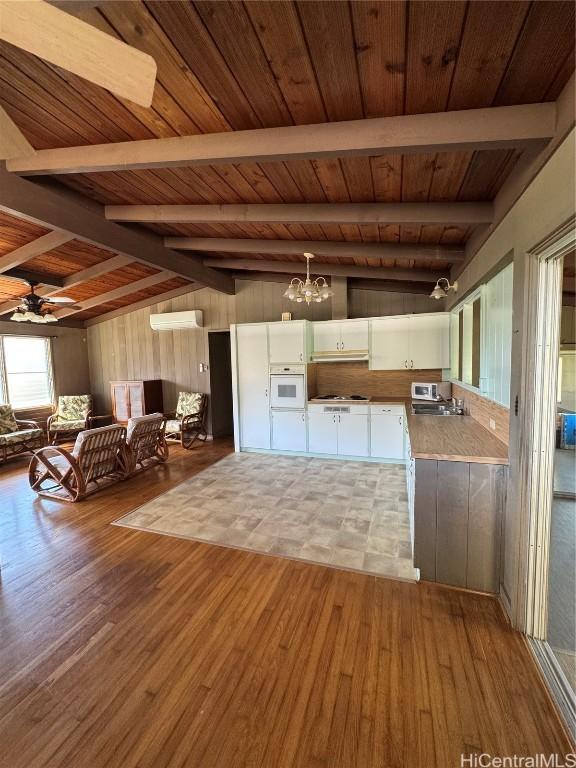 kitchen with white appliances, white cabinetry, a wall mounted air conditioner, light hardwood / wood-style flooring, and wooden ceiling