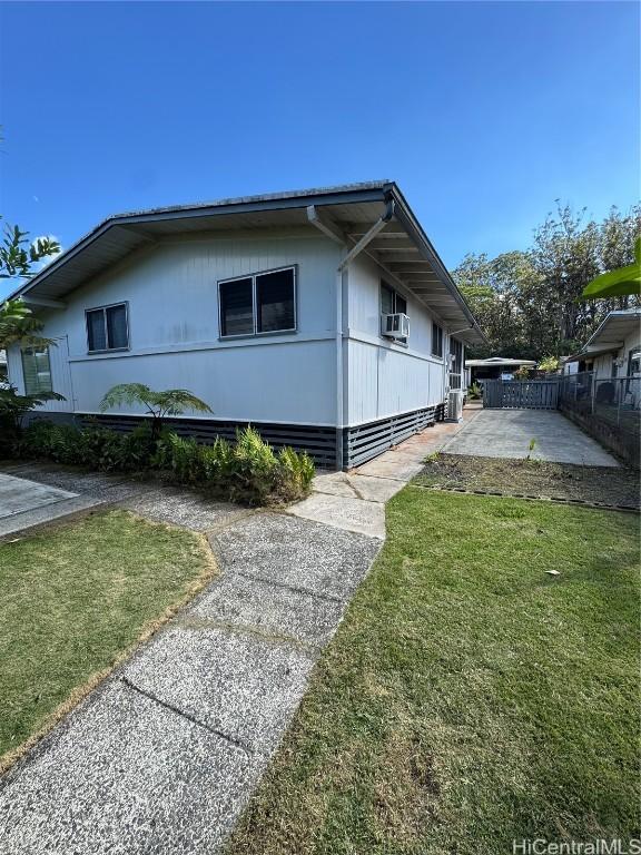 view of property exterior with cooling unit, a lawn, and a patio