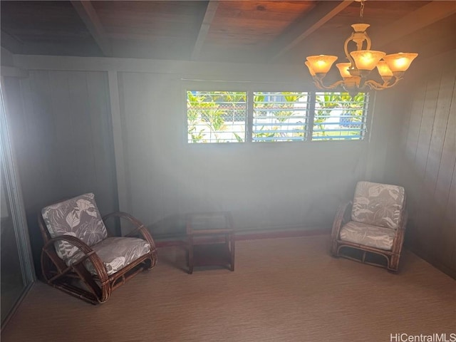 sitting room with carpet floors, beamed ceiling, a notable chandelier, and wooden walls