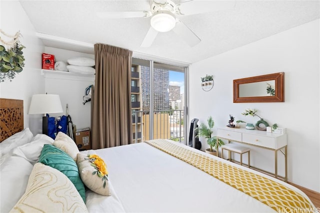 bedroom with access to exterior, expansive windows, ceiling fan, and hardwood / wood-style flooring