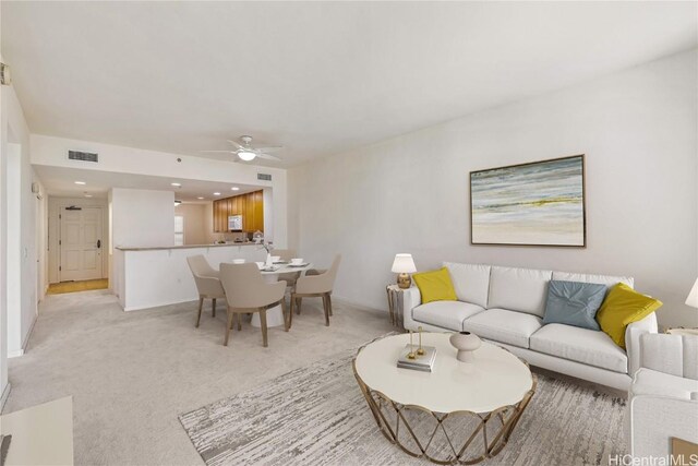 living room featuring light colored carpet and ceiling fan