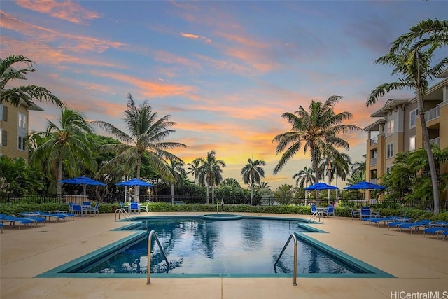 pool at dusk with a patio area