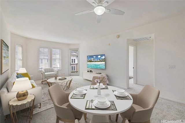 dining space with light colored carpet and ceiling fan