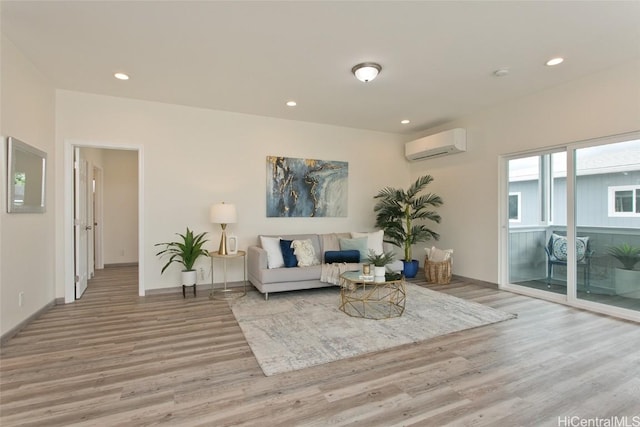 living room with light hardwood / wood-style floors and a wall unit AC