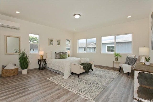 bedroom with hardwood / wood-style flooring and a wall unit AC