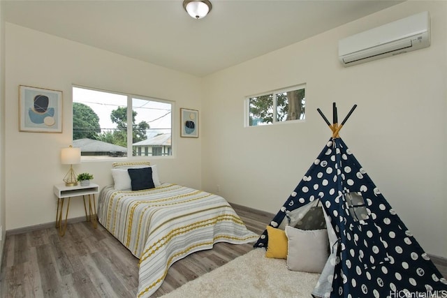 bedroom featuring hardwood / wood-style floors and an AC wall unit