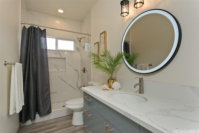 bathroom featuring hardwood / wood-style flooring, vanity, curtained shower, and toilet