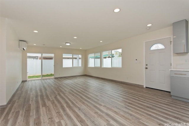 interior space with light hardwood / wood-style floors and a wall mounted air conditioner