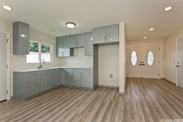 kitchen featuring gray cabinetry, light hardwood / wood-style floors, and sink