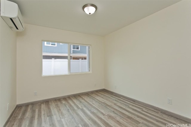 spare room with light hardwood / wood-style floors and a wall mounted air conditioner