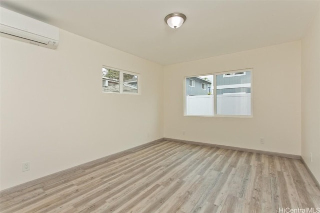 spare room featuring light hardwood / wood-style floors and a wall unit AC