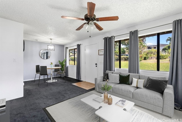 carpeted living room with ceiling fan and a textured ceiling