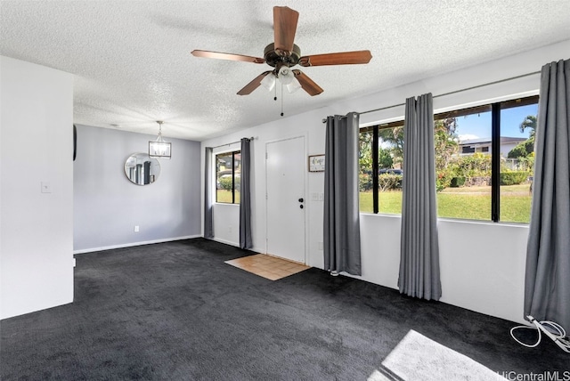 carpeted spare room featuring ceiling fan and a textured ceiling