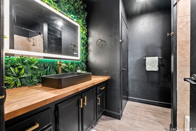 bathroom featuring a shower, hardwood / wood-style floors, and vanity