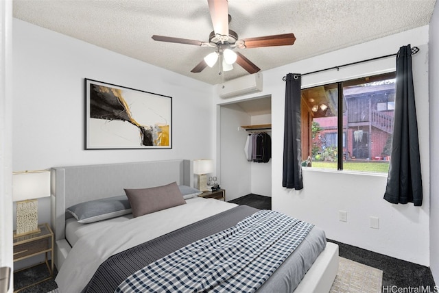 bedroom featuring a wall mounted AC, ceiling fan, a closet, and a textured ceiling