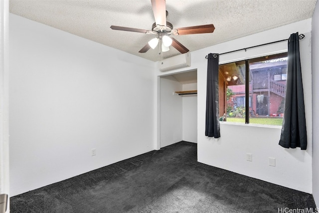 carpeted spare room with a textured ceiling, ceiling fan, and a wall mounted air conditioner