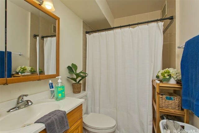 bathroom featuring vanity, curtained shower, and toilet