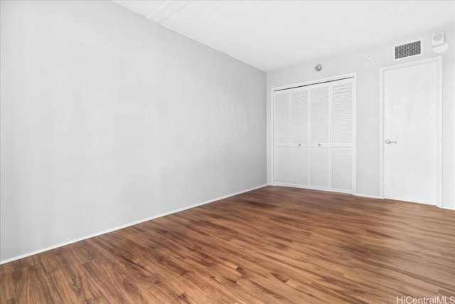 unfurnished bedroom with hardwood / wood-style floors and a closet