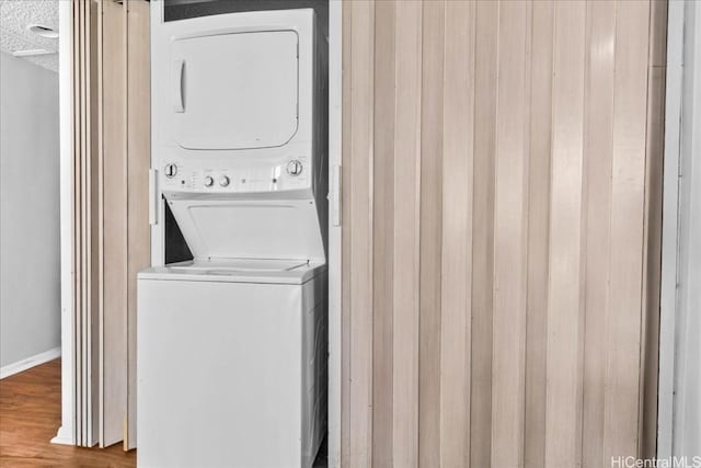 washroom featuring stacked washer and dryer, hardwood / wood-style floors, and a textured ceiling