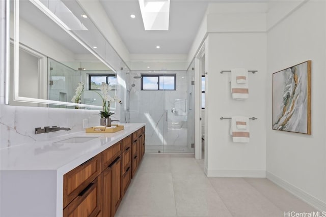 bathroom featuring walk in shower, a skylight, and vanity