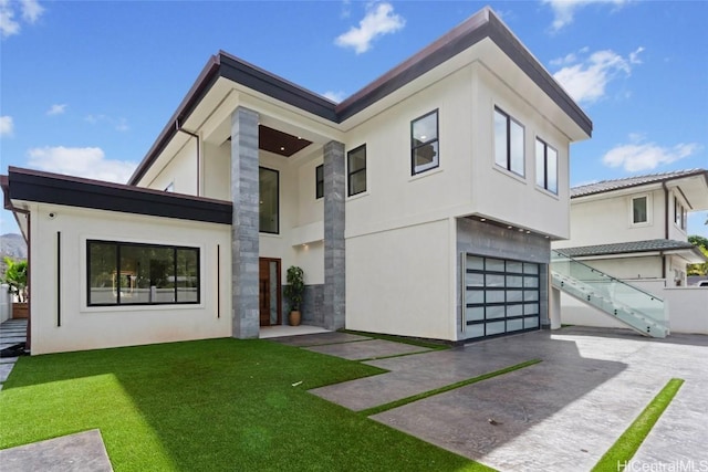 contemporary home featuring a front yard and a garage