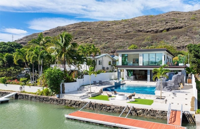 rear view of property featuring a water and mountain view and a patio area