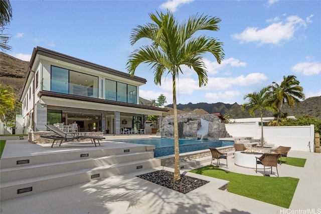 view of pool featuring pool water feature, an outdoor fire pit, a mountain view, and a patio