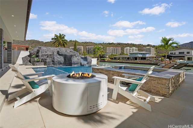 view of pool with pool water feature, a jacuzzi, an outdoor fire pit, and a patio