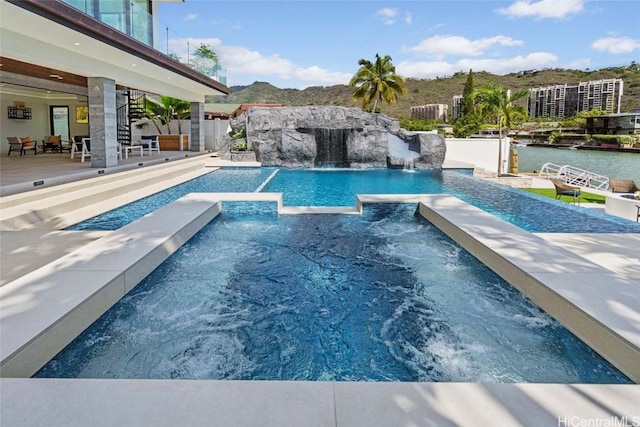 view of pool featuring a water and mountain view, a jacuzzi, and pool water feature