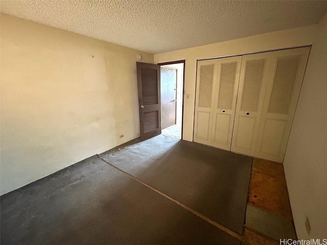 unfurnished bedroom featuring a textured ceiling and a closet