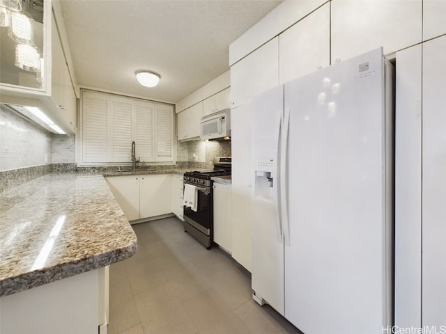 kitchen with sink, a textured ceiling, white appliances, decorative backsplash, and white cabinets