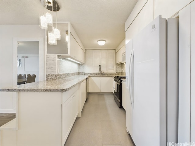 kitchen with stainless steel gas range, white cabinetry, kitchen peninsula, a notable chandelier, and pendant lighting