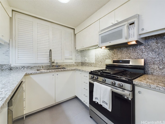 kitchen featuring sink, appliances with stainless steel finishes, tasteful backsplash, a textured ceiling, and white cabinets