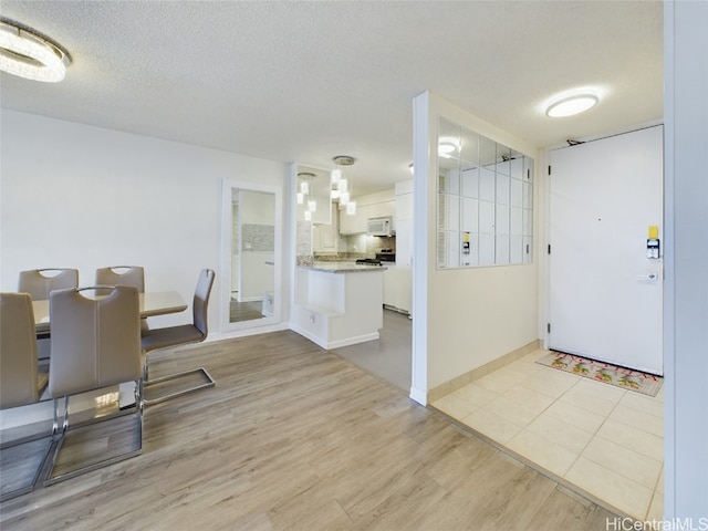 dining space featuring a textured ceiling and light hardwood / wood-style flooring