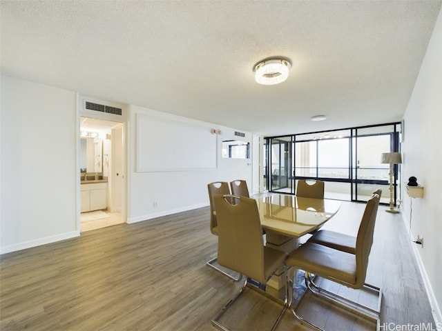 dining area with expansive windows, dark wood-type flooring, and a textured ceiling