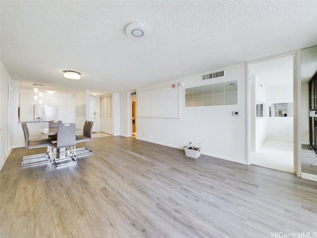 dining room featuring light hardwood / wood-style flooring and a textured ceiling