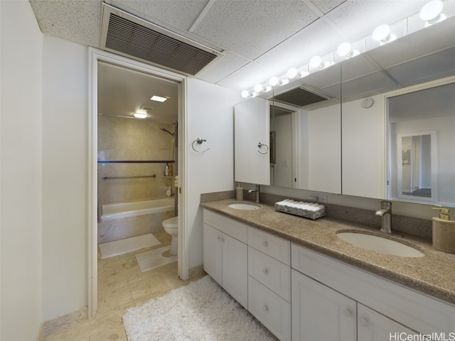 full bathroom featuring a paneled ceiling, vanity, toilet, and tub / shower combination